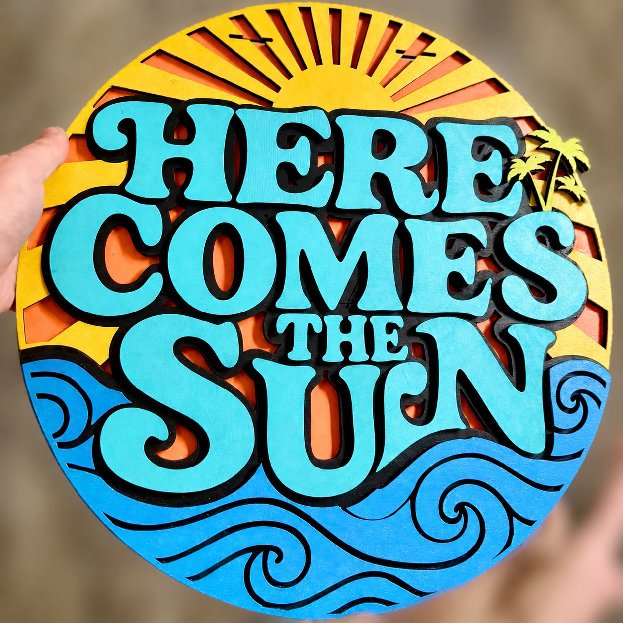 Decorative sign with 'Here Comes the Sun' text and sun design