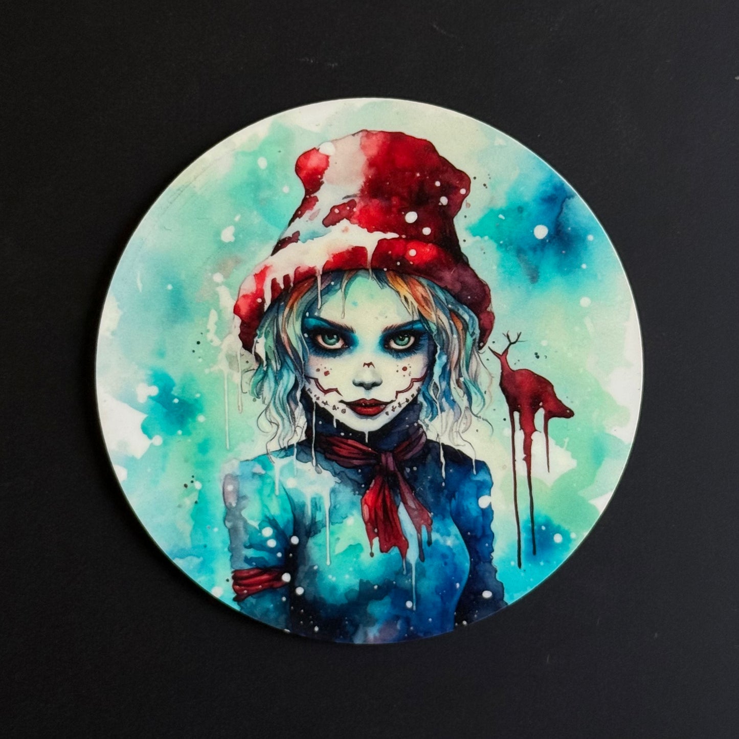 A circular art print or coaster featuring a stylized watercolor illustration of a girl with pale face paint, a red Santa hat, and a blue winter outfit on a black background.