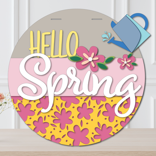 Decorative sign with 'Hello Spring' text and floral designs on a wooden surface.