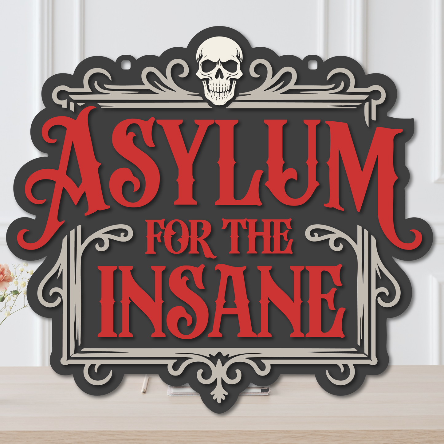 Layered Asylum for the Insane Halloween door hanger with red lettering, skull, ornate cream frame, and black background