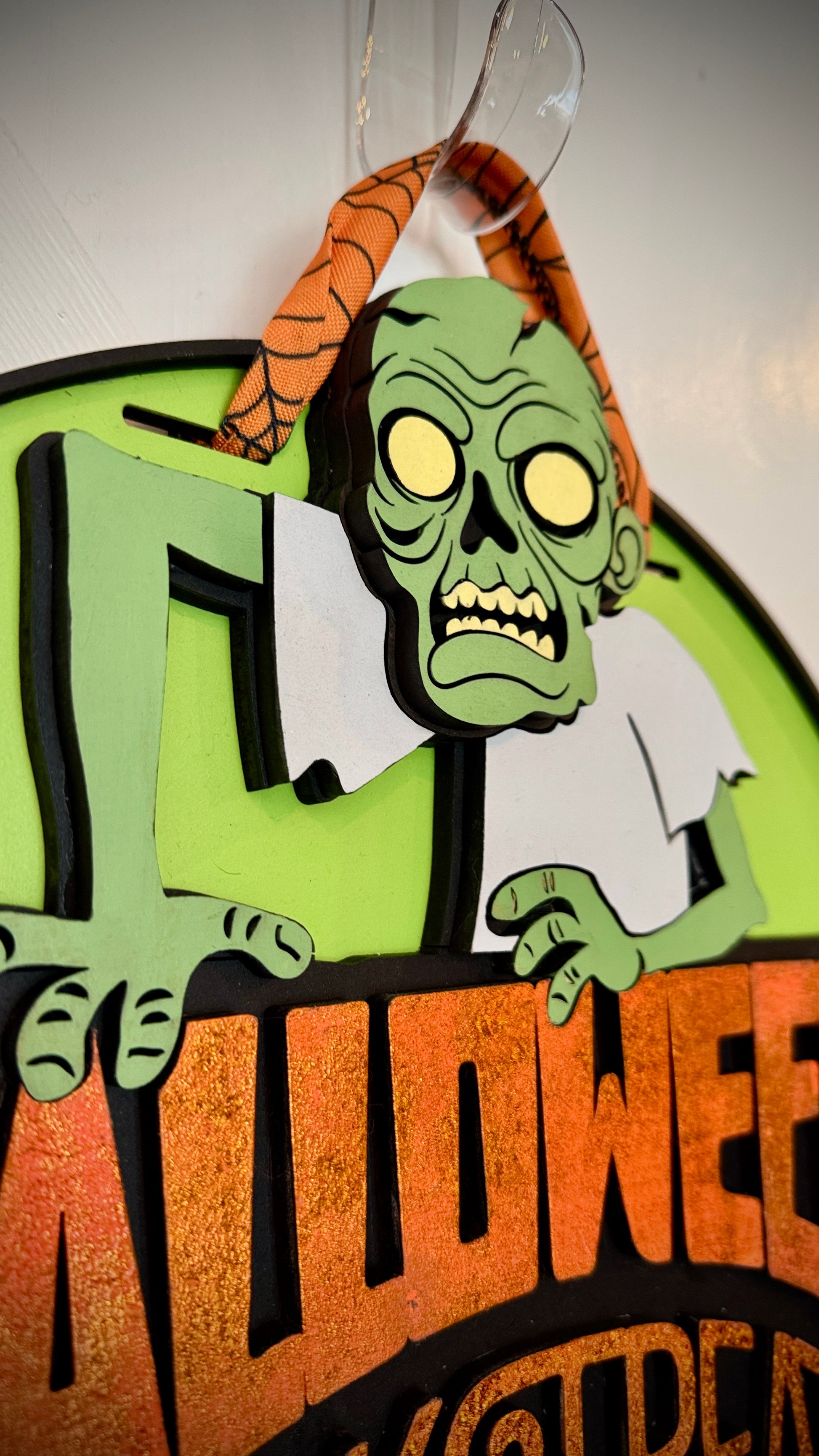 Halloween-themed decoration with a zombie design on a green background