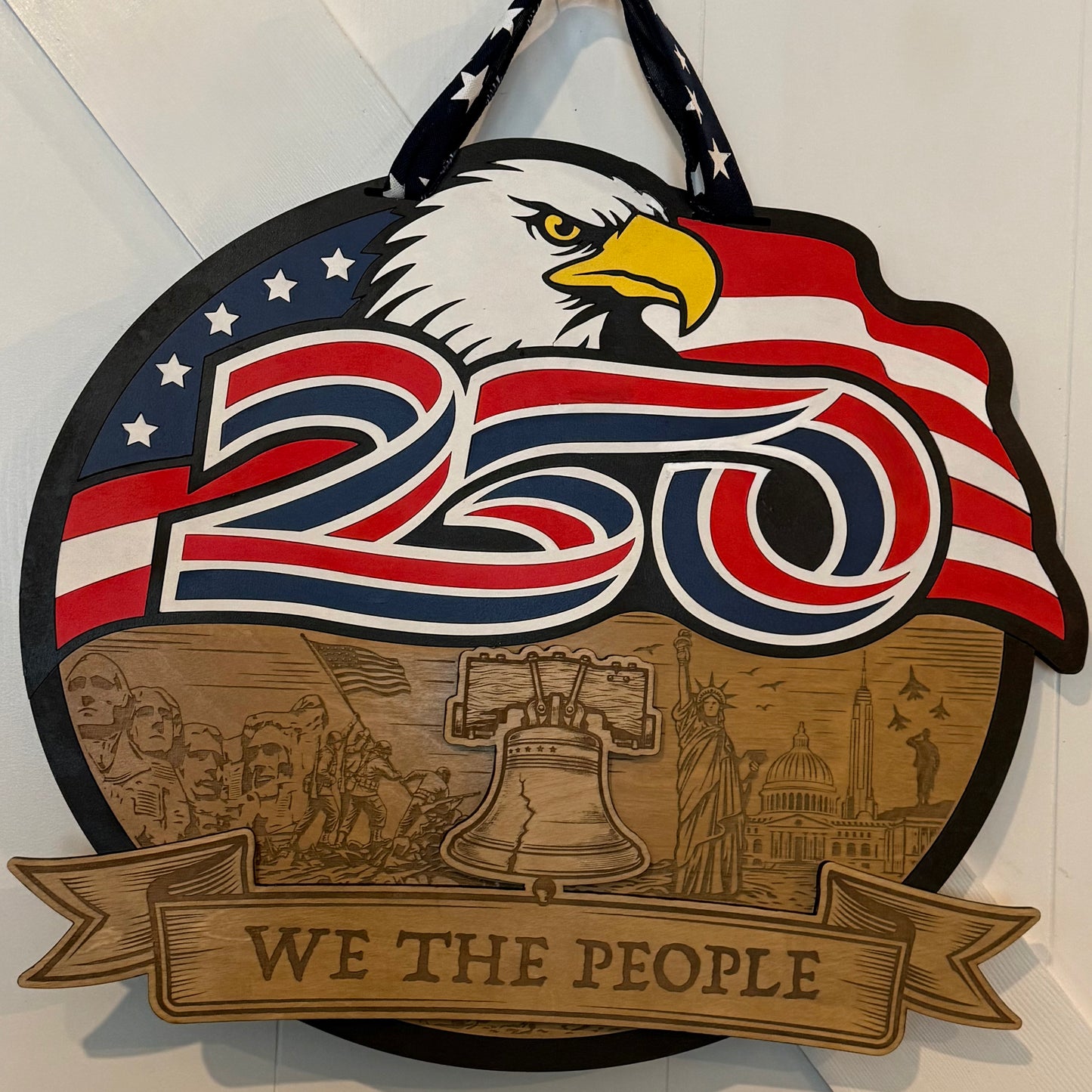 Decorative sign with eagle, American flag, and 'We the People' text on a white background