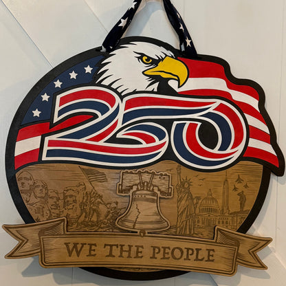 Decorative sign with eagle, American flag, and 'We the People' text on a white background