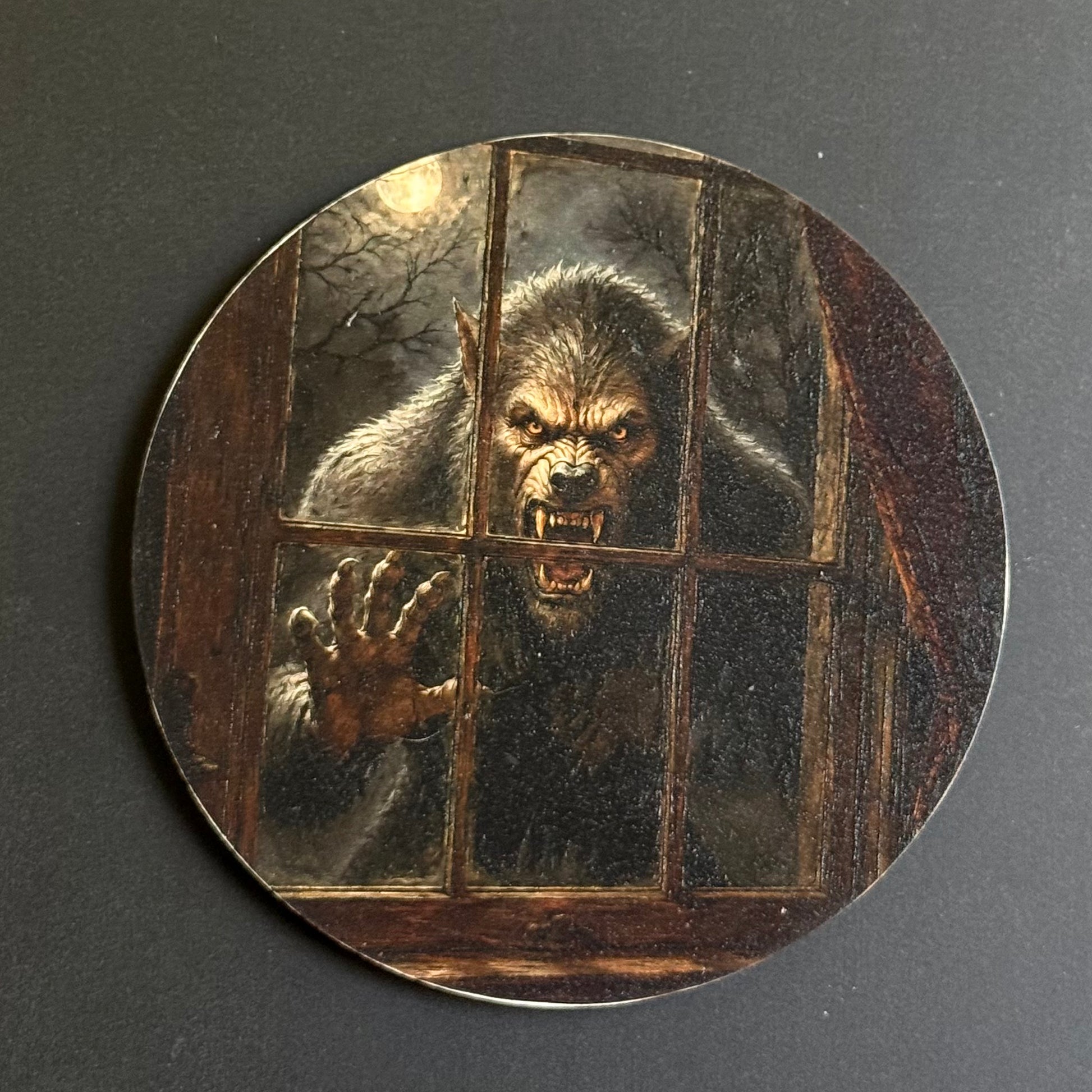 A circular coaster featuring a detailed illustration of a snarling werewolf behind a barred window, set against a dark gray background.