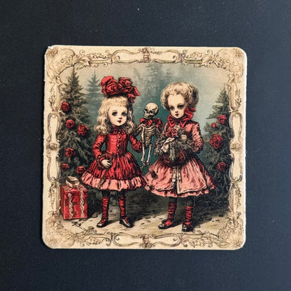A square vintage-style illustrated print or card featuring two young girls in red dresses standing in a dark forest with roses, a skeleton, and a gift box, set against a dark charcoal background.