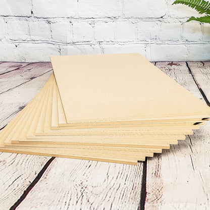 Stack of MDF sheets on a wooden surface with a white brick wall background
