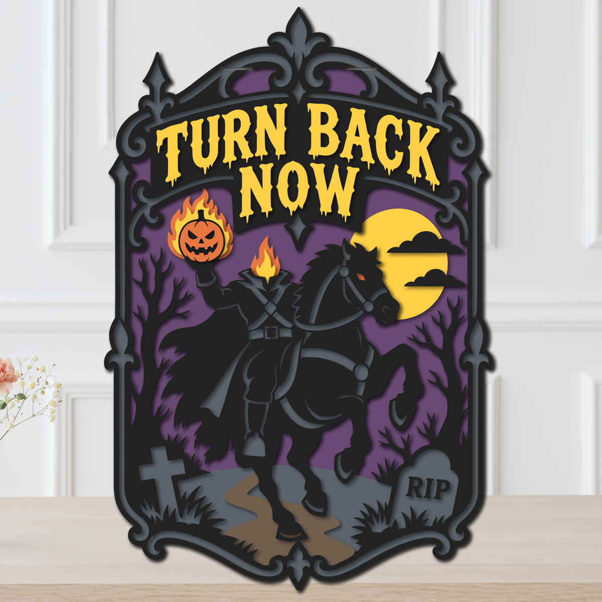 Layered Halloween door hanger with the Headless Horseman on a black horse holding a flaming jack-o'-lantern, a yellow moon, a purple sky and the words Turn Back Now.